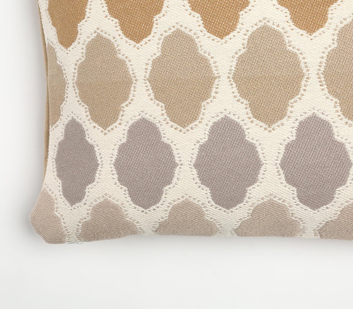 Närbild av det geometriska kuddfodralets beige och grå klövermönster