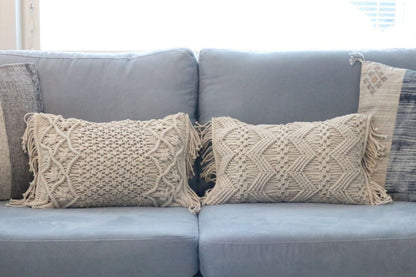 Kaksi makramee ZigZag -tyynyä siniharmaalla sohvalla
